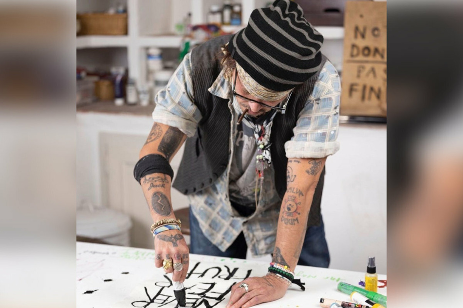 Johnny Depp working on his art, which sold out within hours of going out on sale.