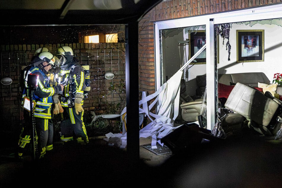 Einsatzkräfte stehen nach einer Explosion neben Trümmern.