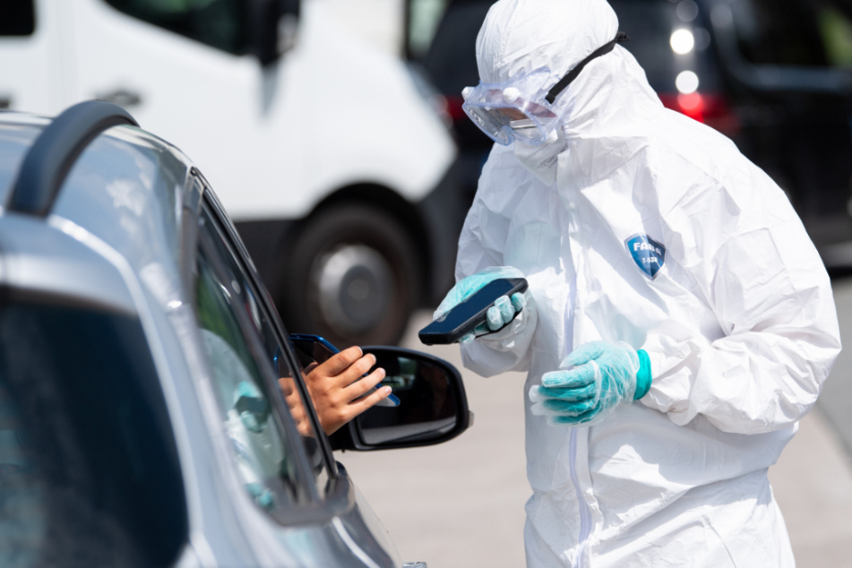 Ein Mitarbeiter der Firma Eurofins scannt an einem Corona-Testzentrum an der Autobahn 93 (A93) an der Rastanlage Inntal-Ost das Smartphone einer Person. (Symbolbild)