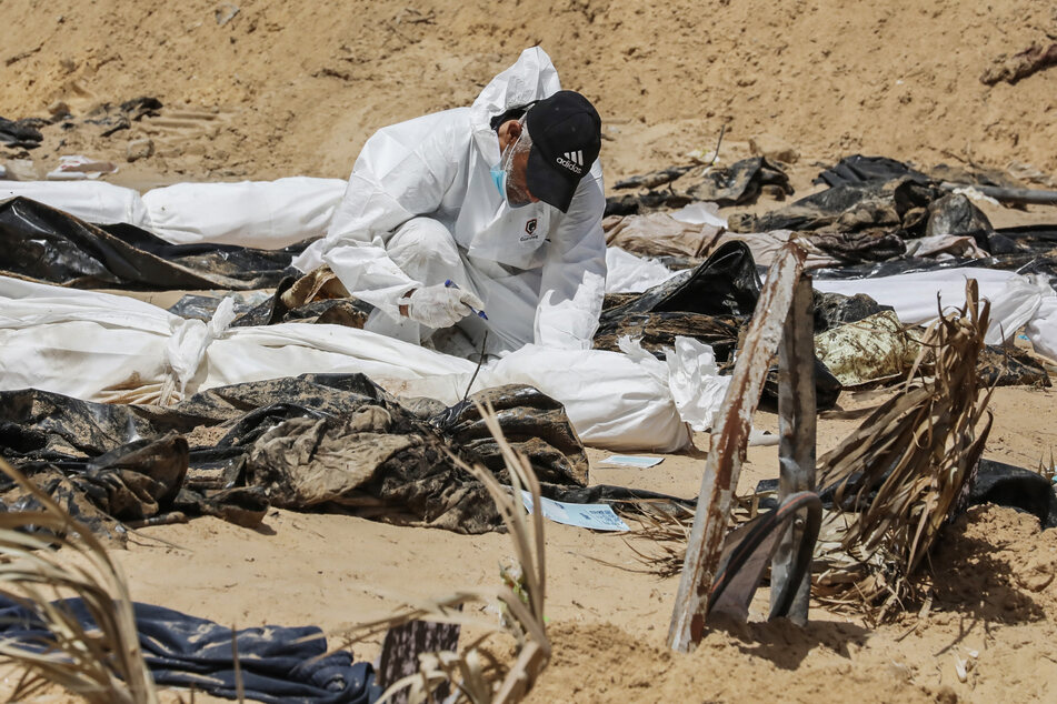 Palästinensisches Gesundheitspersonal gräbt die Leichen von Palästinensern aus, die auf dem Gelände des Nasser-Krankenhauses begraben wurden.