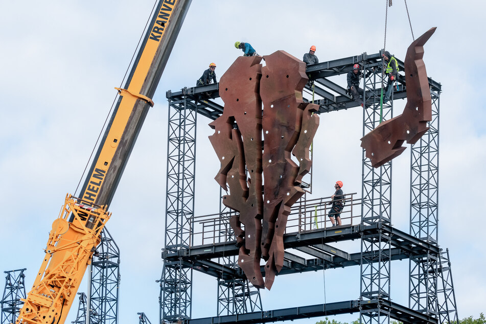 Arbeiter montieren den Wacken-Schädel, das Symbol des Festivals, zwischen den beiden Hauptbühnen.
