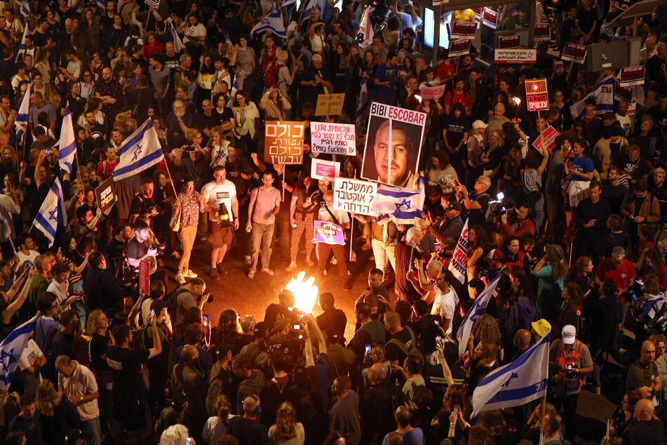 Angehörige und Unterstützer von Geiseln hielten Plakate und schwenkten Nationalflaggen während einer Demonstration in der israelischen Küstenstadt Tel Aviv.