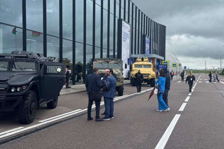 Unternehmer begutachten gepanzerte Fahrzeuge beim Internationalen Wirtschaftsforum in St. Petersburg. Zuvor waren in der nähe ukrainische Drohnen eingeschlagen.