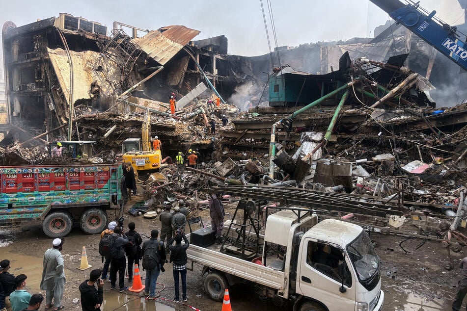 Mit schwerem Gerät durchsuchen Rettungskräfte und die Feuerwehr die Trümmer.