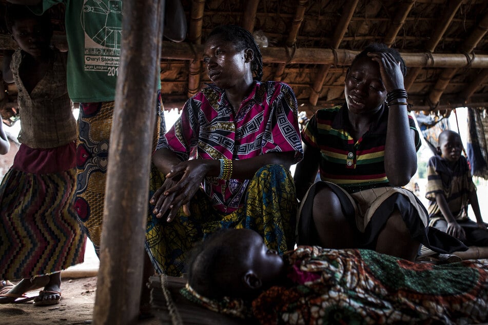 A mother reacts after her fifteen-month-old baby passed away as an outbreak of malaria hit their village on June 12, 2017 in Muma.