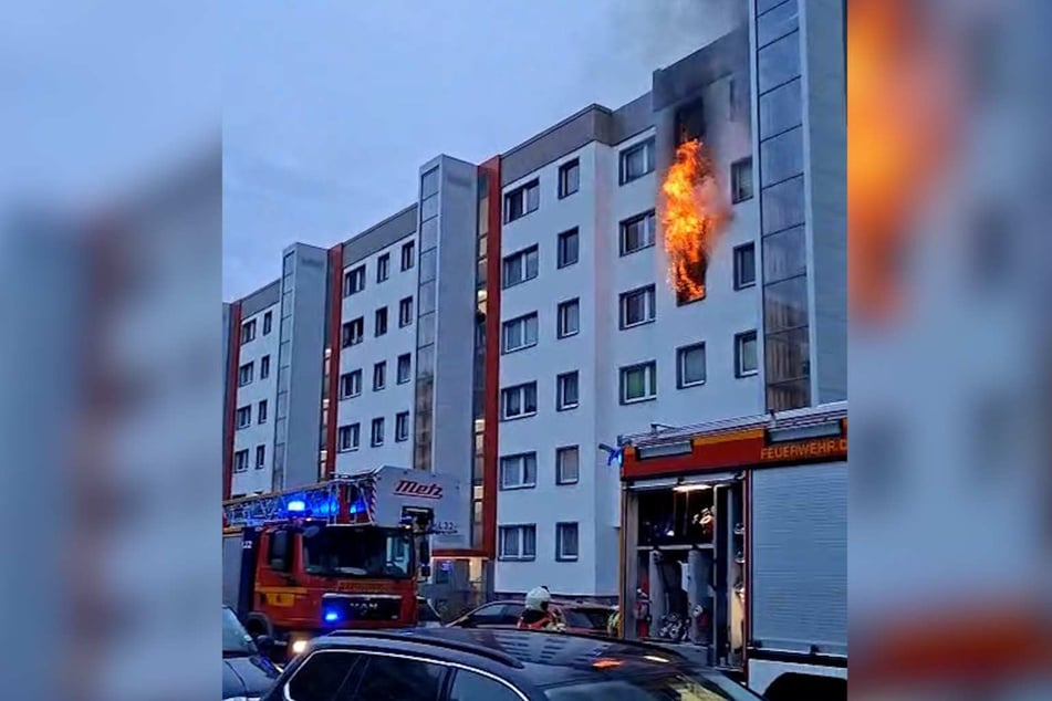 Flammen schlagen aus der Wohnung im dritten Stock.