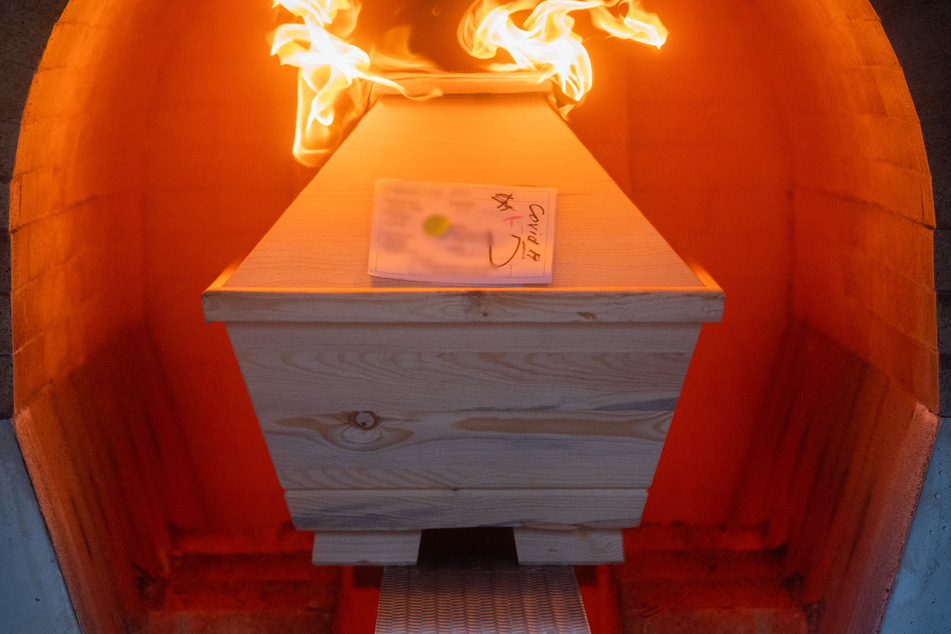 Ein Verstorbener in einem Sarg mit Aufschrift "Covid-19" wird im Krematorium "Die Feuerbestattungen Hildesheim" in einem Ofen eingeäschert. Vier Prozent der Todesfälle 2020 gehen direkt auf Corona zurück.