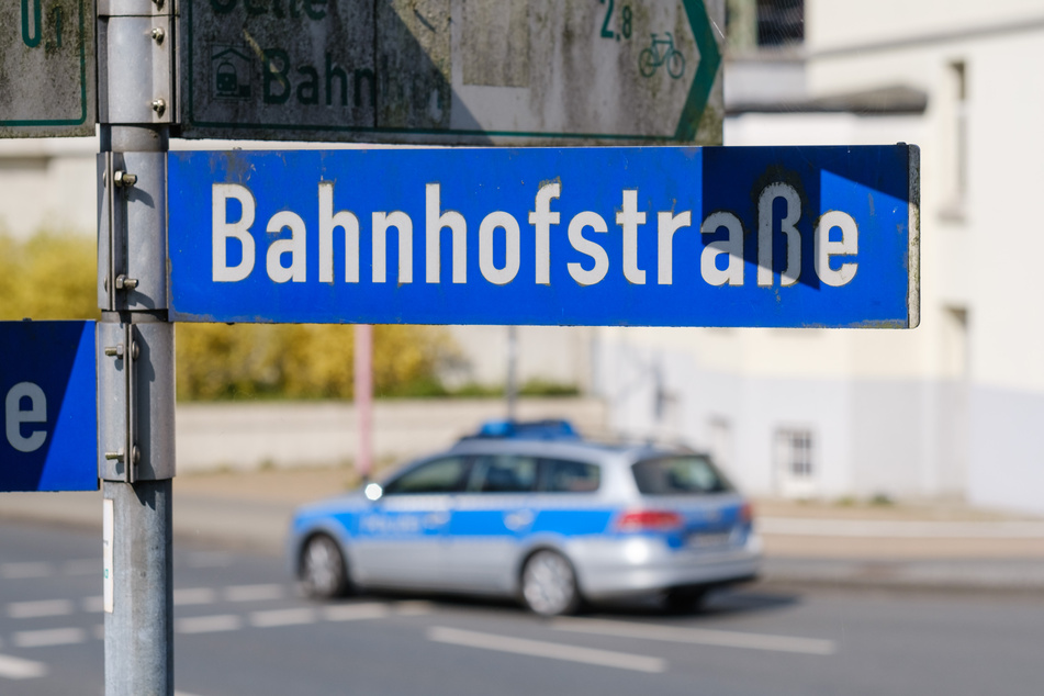 Ein Polizeiauto fährt an dem Straßenschild "Bahnhofstraße" vorbei, wo der 15-Jährige erstochen wurde.