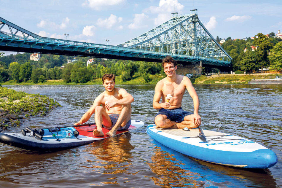 Alex (19,l.) und Felix (20) machten es richig: Die Stand-up-Paddler genossen gestern ihr Eis auf der kühlenden Elbe am Blauen Wunder.
