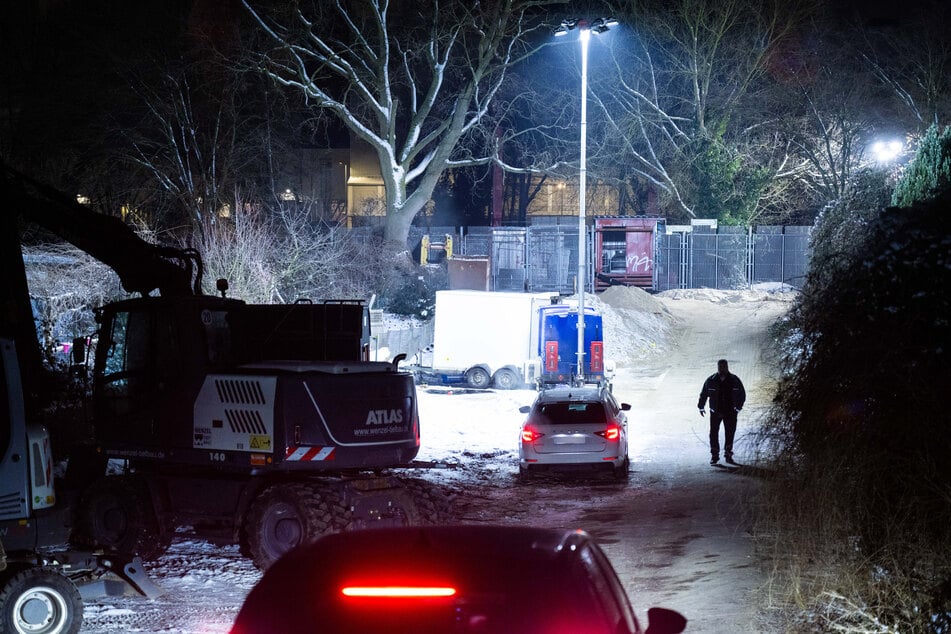 Sicherheitsleute bewachen die Brandstelle einer Kabelbrücke vor dem Kraftwerk Lichterfelde am Teltowkanal.