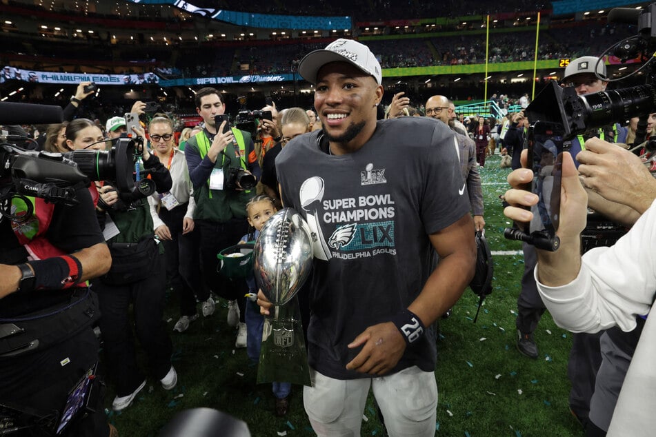 The Philadelphia Eagles' Saquon Barkley celebrates with the Vince Lombardi Trophy after winning Super Bowl LIX.