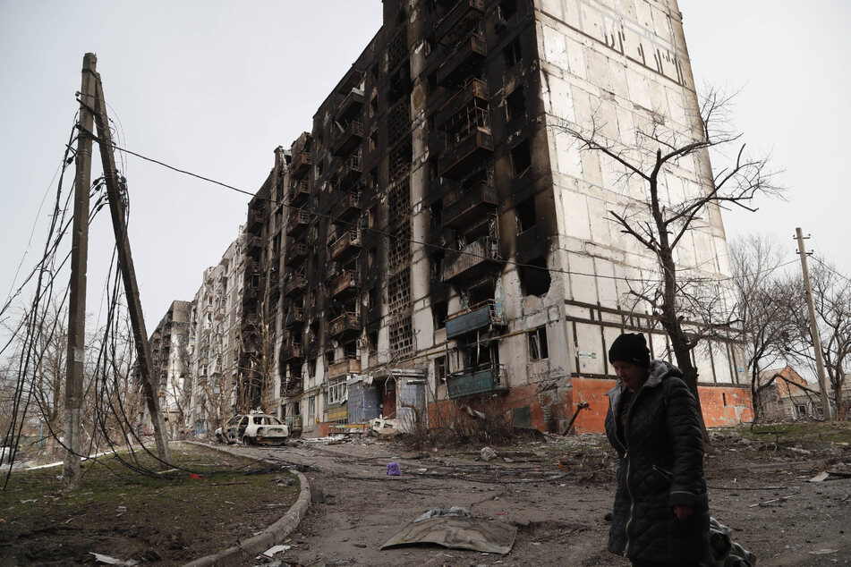 A woman walks past a destroyed building in Mariupol, Ukraine.