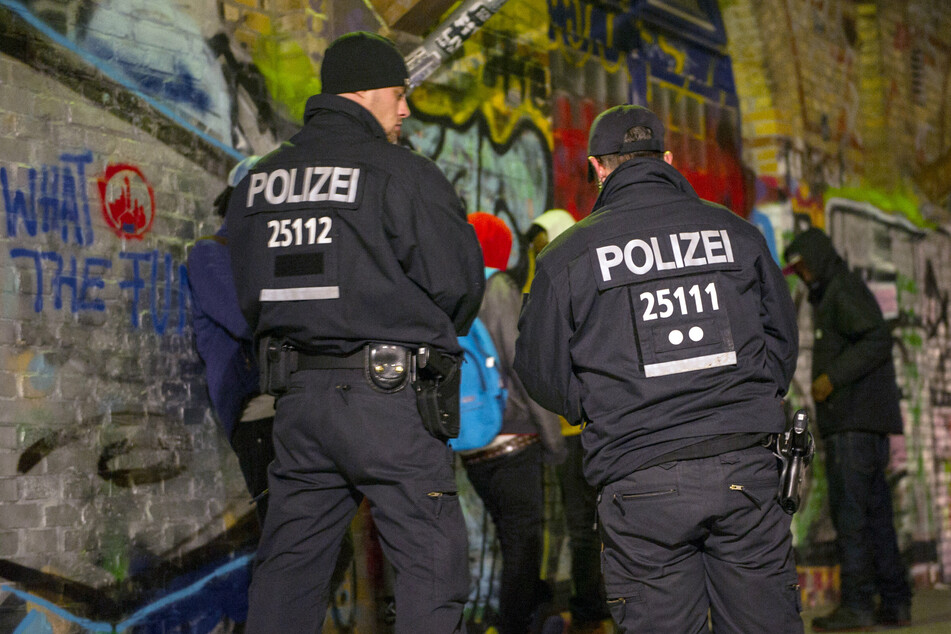 Polizisten stehen im November 2014 bei einer Polizeiaktion im Görlitzer Park vor Personen, die kontrolliert werden sollen. (Archivbild)