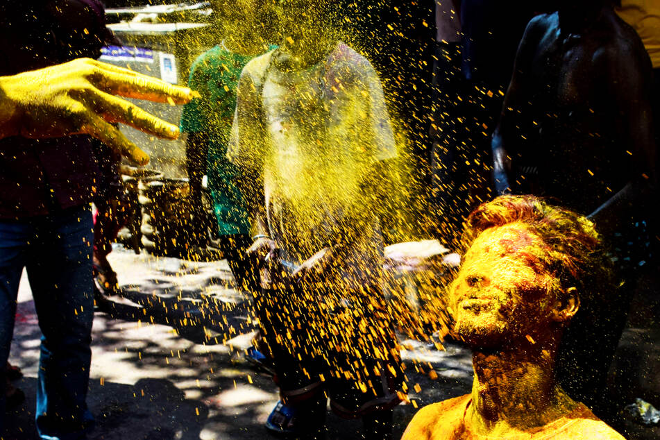 Ein Junge wird während des Holi-Festivals im indischen Kalkutta mit Farbe besprüht.