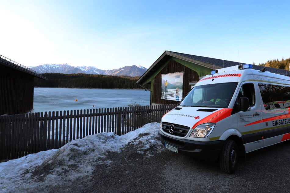 Ein Einsatzfahrzeug des Roten Kreuzes steht am Ufer des Eibsees.