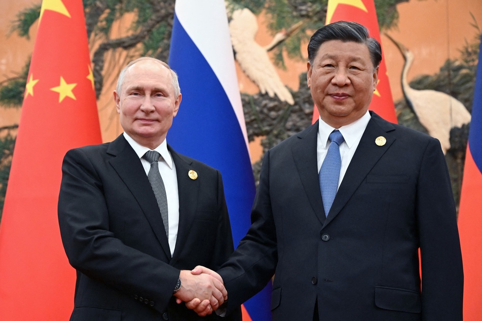 Russia's President Vladimir Putin (l.) and Chinese President Xi Jinping shake hands during a meeting in Beijing on October 18.
