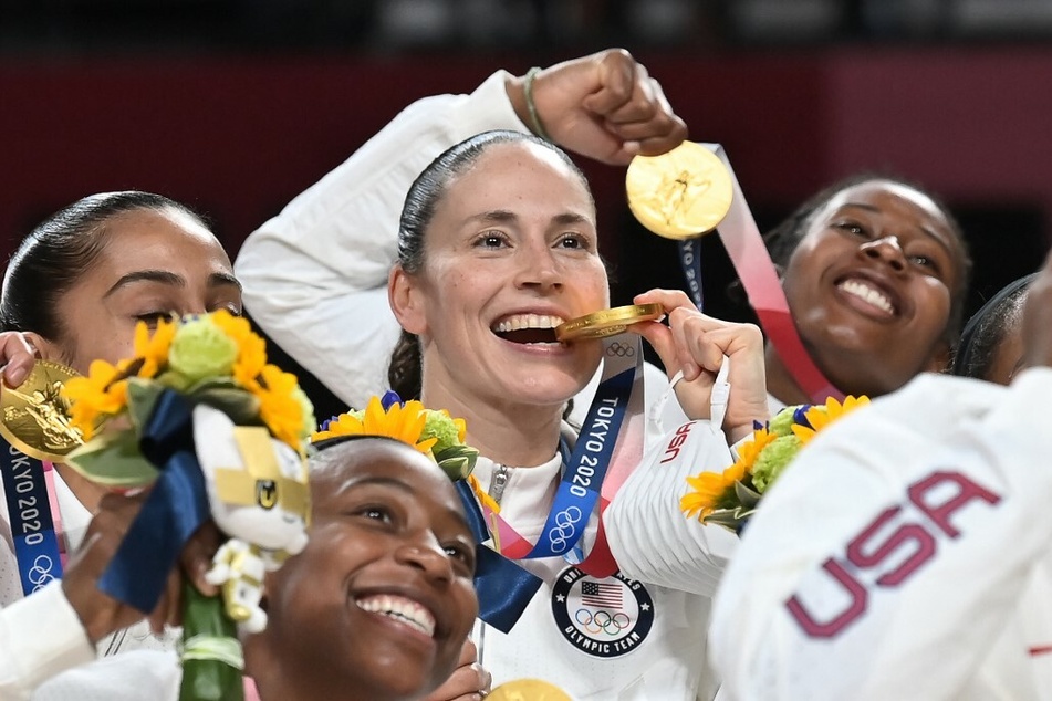 Sue Bird (c.) celebrated her gold medal with her teammates at the Tokyo 2020 Olympic Games.