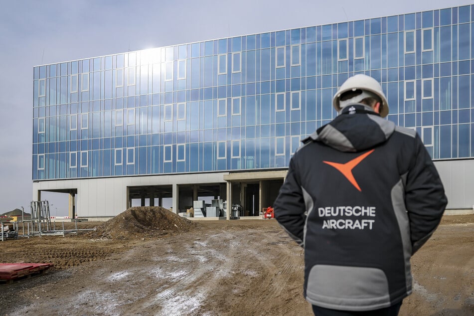 Ein Mitarbeiter der Deutschen Aircraft geht über die Baustelle für ein neues Flugzeugwerk am Flughafen Leipzig/Halle.