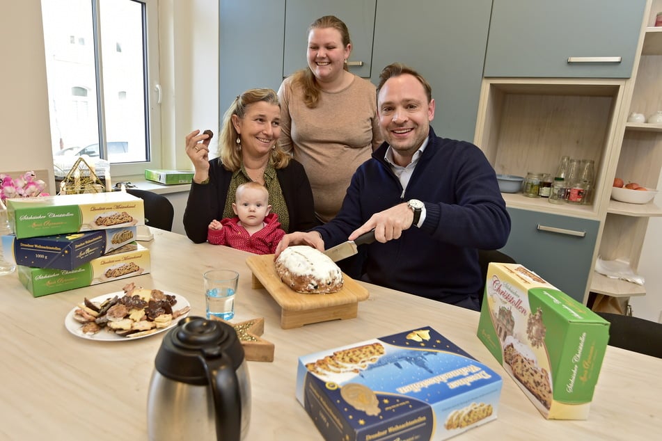 Alexander Dierks (37, r.) schneidet im Karree 49 mit Leiterin Angelika Scheuerl (57), Enkelin Annabel (8 Monate) und Tochter Ronja (24) Stollen an.