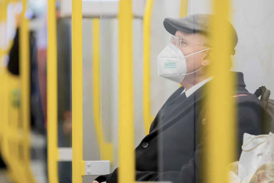 Ein Mann sitzt mit FFP2-Maske in der U-Bahn. Bei den Bund-Länder-Gesprächen zu den Maßnahmen gegen die Corona-Pandemie wurden einige Regeln verschärft.