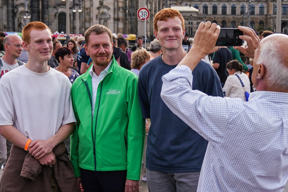 Kein Käse, sondern "Cheese": MP Michael Kretschmer (49, CDU) lächelt mit Bürgern in die Kamera.