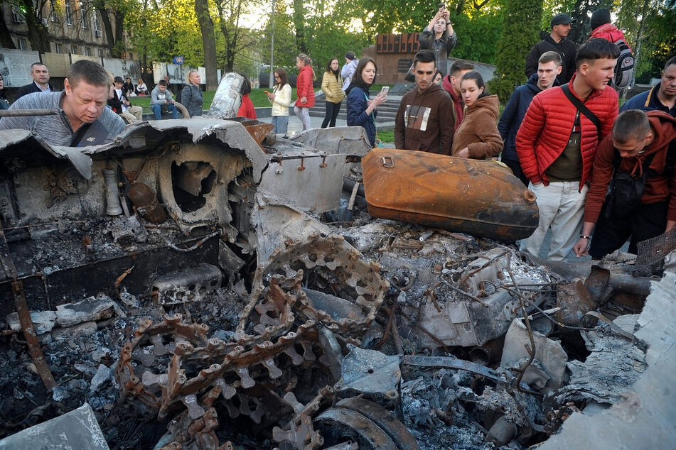 Menschen begutachten einen russischen Panzer und einen Transportpanzer, die bei schweren Kämpfen zerstört wurden.