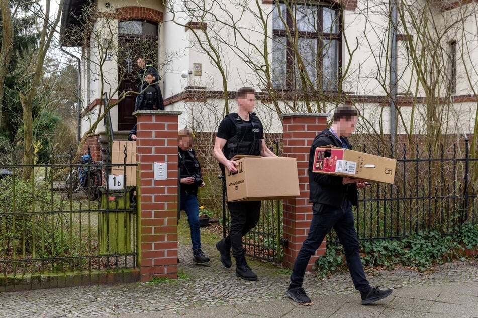 Kistenweise schleppten Beamte Beweismaterial aus Büros und Wohnhäusern.