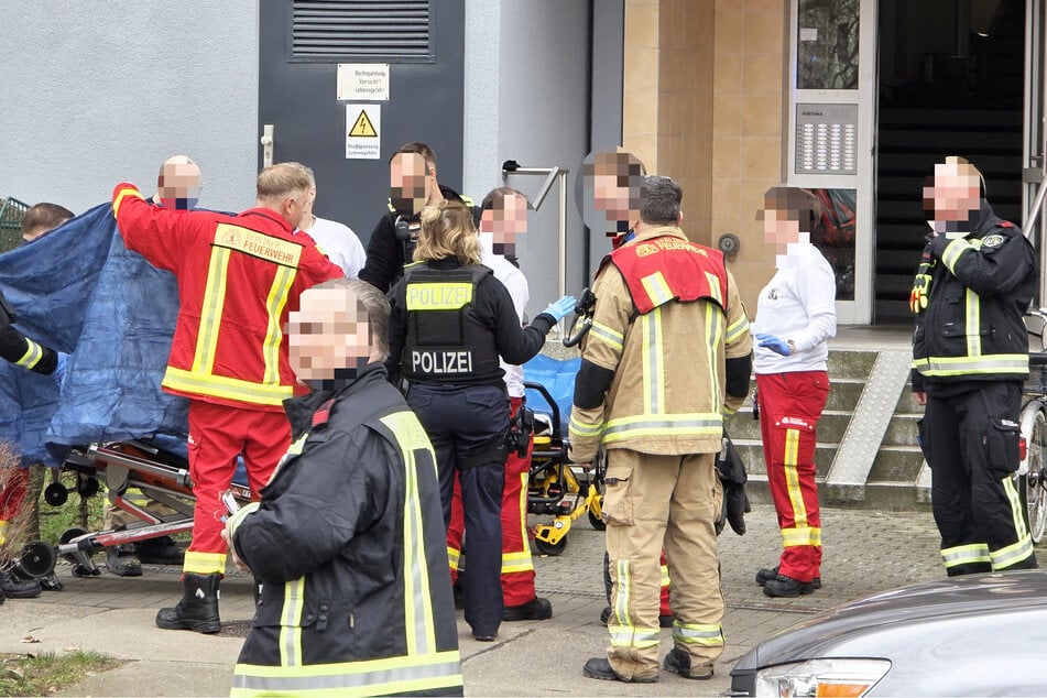 Einsatzkräfte schirmen beim Abtransport die schwer verletzte Frau ab.