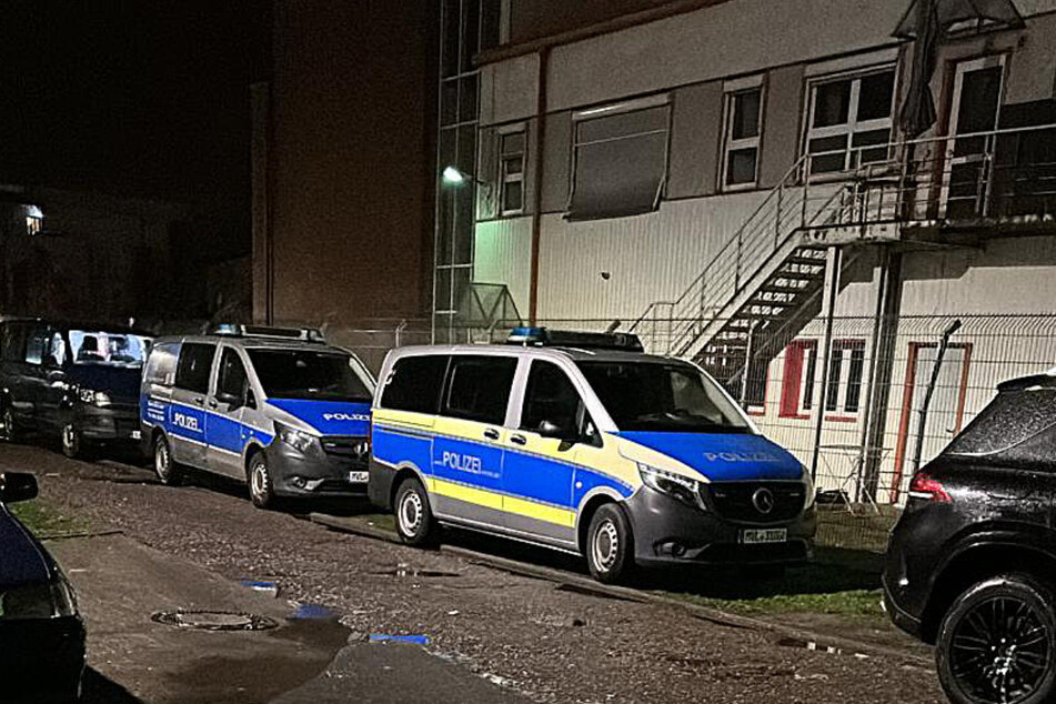 Polizeiautos stehen am Sonntagabend vor der Geflüchtetenunterkunft in Rostock-Schmarl.
