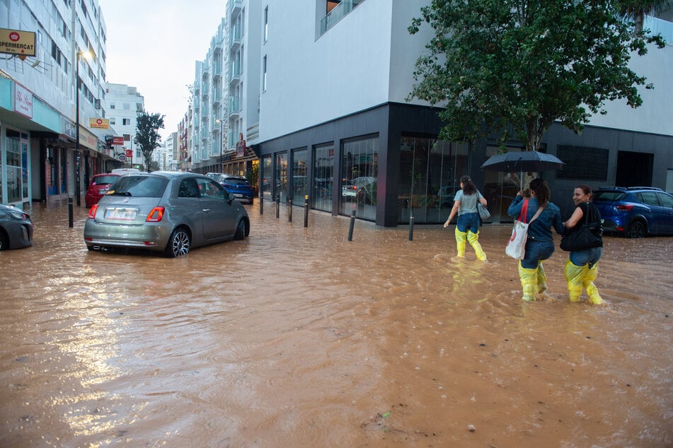 Trotz des gewaltigen Regens durchkämen einige Anwohner und Autos die durchfluteten Wege.
