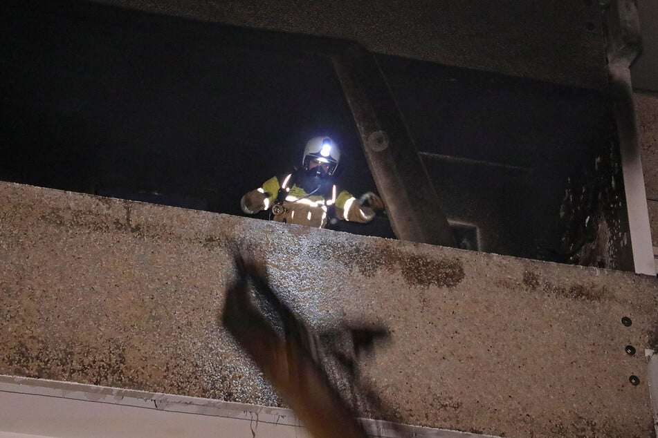 Feuerwehrleute warfen verkohlte Gegenstände zu Boden.