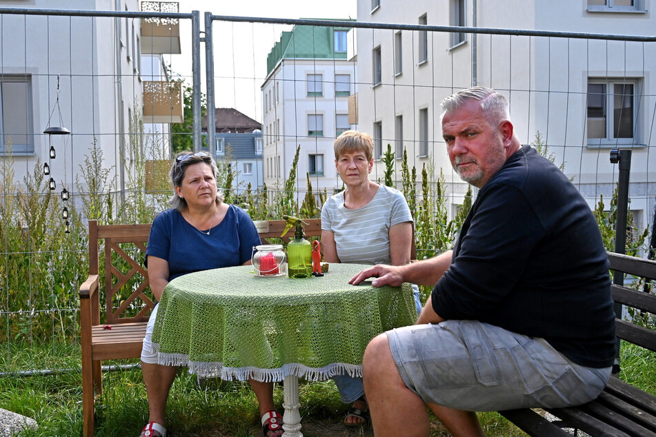 Hinter Gittern (v.l.): Annett Hebenstreit (57), Steffi Merdon (62) und Maik Hebenstreit (57) haben seit mehr als zwei Jahren einen Bauzaun vor der Nase.