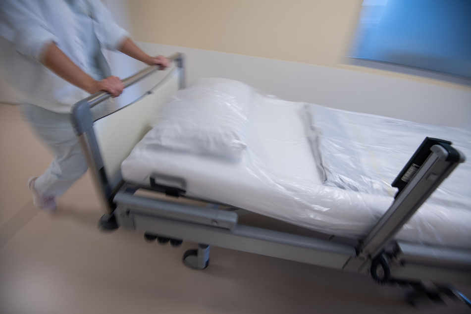 Eine Krankenpflegerin schiebt ein Bett durch den Gang einer Station. (Symbolfoto)