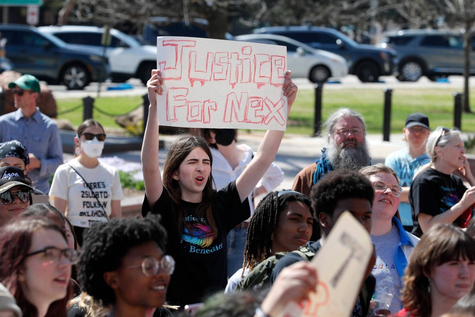 People hold signs calling for justice during a march for Nex Benedict at the state Capitol in Oklahoma City.