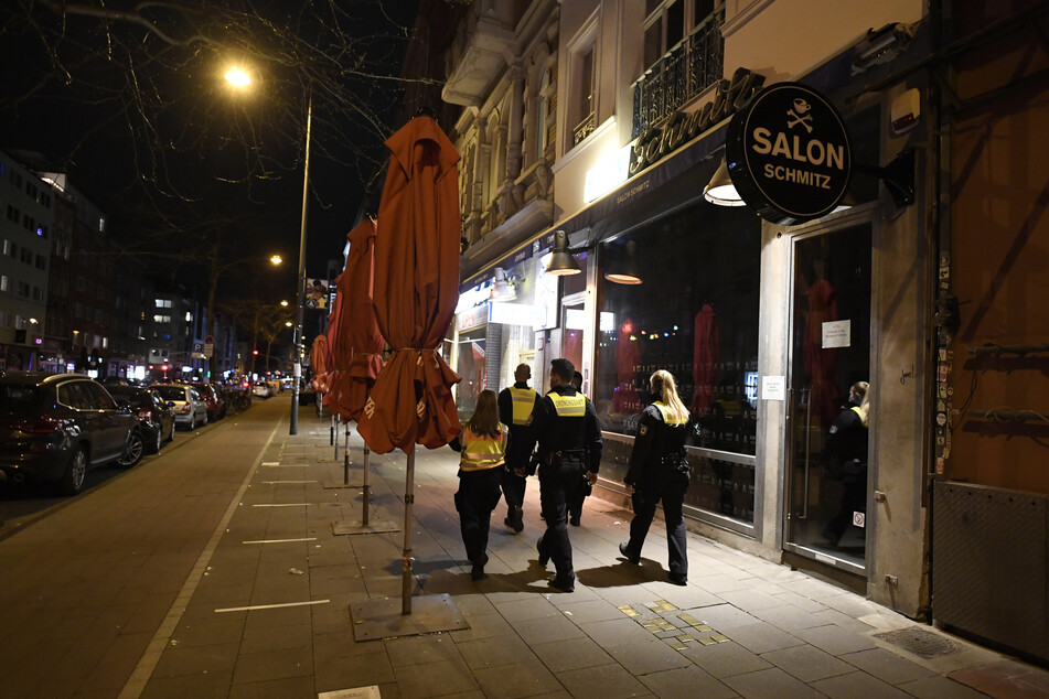Mitarbeiter der Ordnungsamtes Köln patrouillieren durch die verlassene Aachener Straße, wo sonst das Nachtleben tobt.
