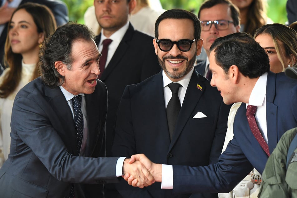 Colombia's far-right president-elect Abelardo de la Espriella (m) smiles as Medellin's Mayor Federico Gutierrez (l) and Colombia's Interior Minister-elect Rodrigo Lara (r) shake hands.