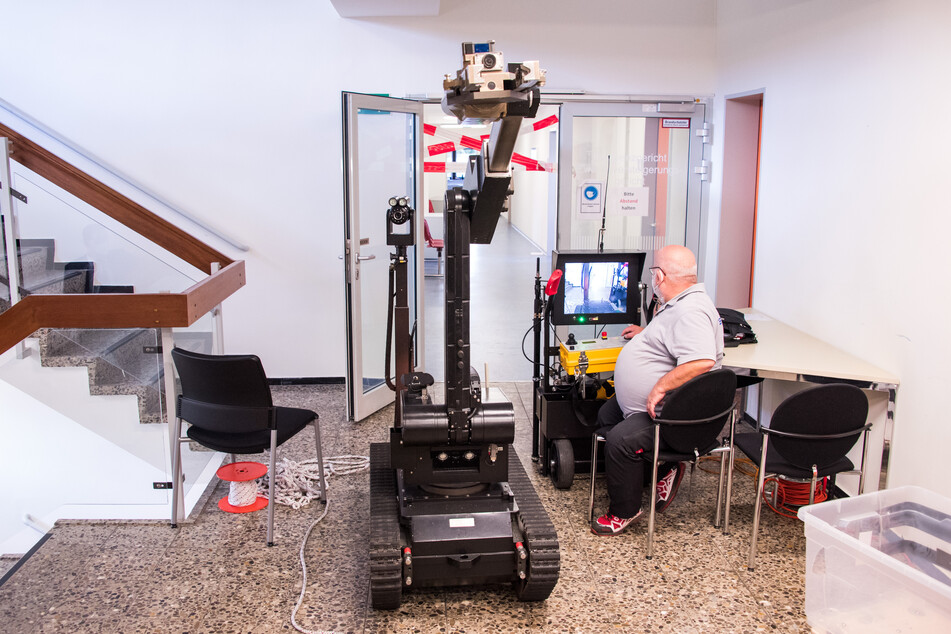 Ein Mitarbeiter navigiert im Amtsgericht Pinneberg einen der Roboter über einen gesperrten Flur.