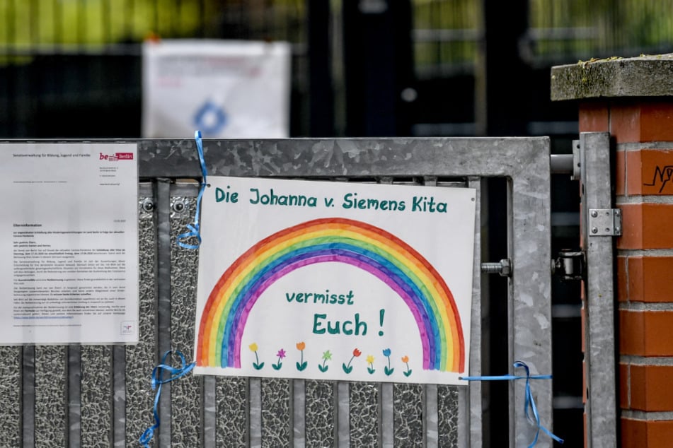 Berlin: An dem Zaun eines Kindergartens hängt ein Schild mit der Aufschrift "Die Johanna v. Siemens Kita vermisst Euch!"