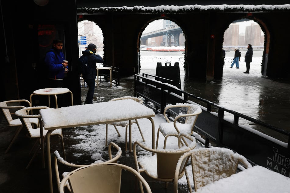 Menschen laufen nach einem nächtlichen Sturm durch die Brooklyn Bridge in New York hindurch.