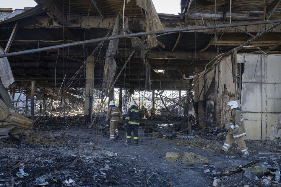 Feuerwehrleute des Staatlichen Katastrophenschutzes beseitigen die Trümmer des angegriffenen Einkaufszentrums in Krementschuk.