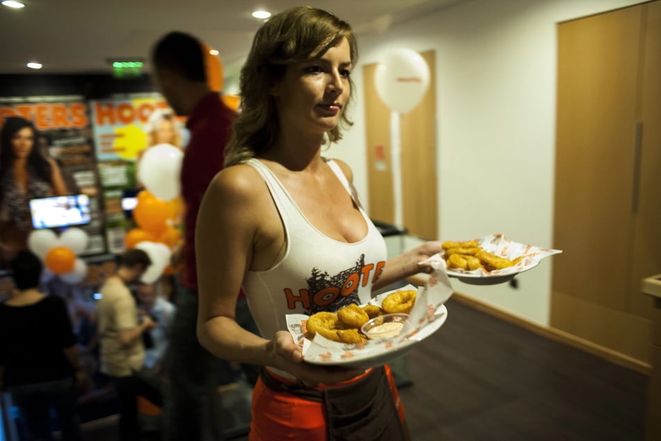 Eine Hooters-Angestellte beim Servieren von Zwiebelringen. (Archivbild)