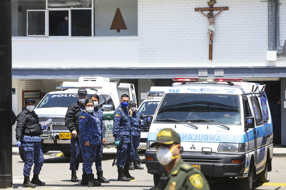 Polizei und Gefängniswärter stehen neben Krankenwagen im Gefängnis "La Modelo".
