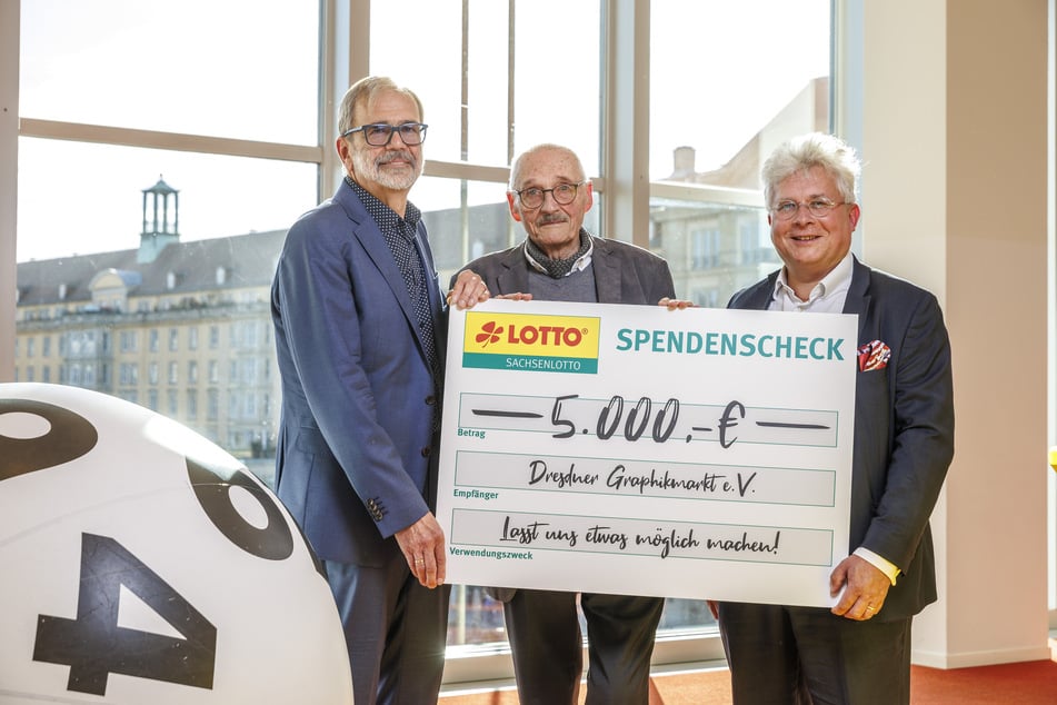 Prof. Harald Marx (84, M.) und Sachsenlotto-Chef Frank Schwarz (57, r.) überreichen an Grafikmarkt-Vereinschef Norbert Sebastian (71) den "Möglichmacher"-Scheck über 5000 Euro.