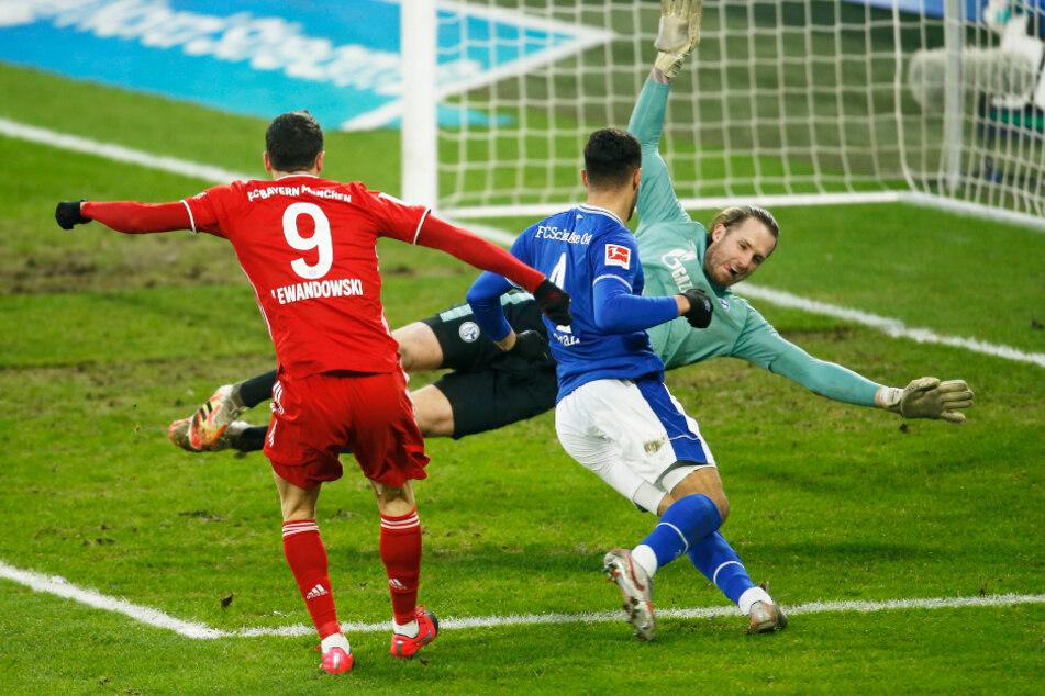 Robert Lewandowski (l.) erzielt das Tor zum 0:2 gegen Schalkes Ozan Kabak und Torwart Ralf Fährmann.