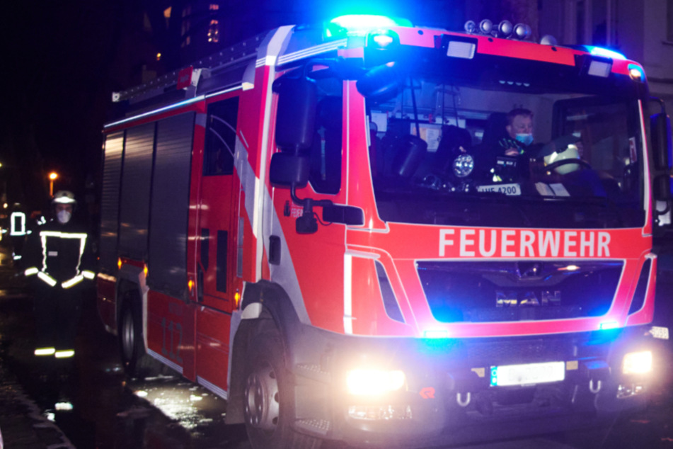Ein Feuerwehrmann läuft neben einem Einsatzwagen. (Symbolbild)