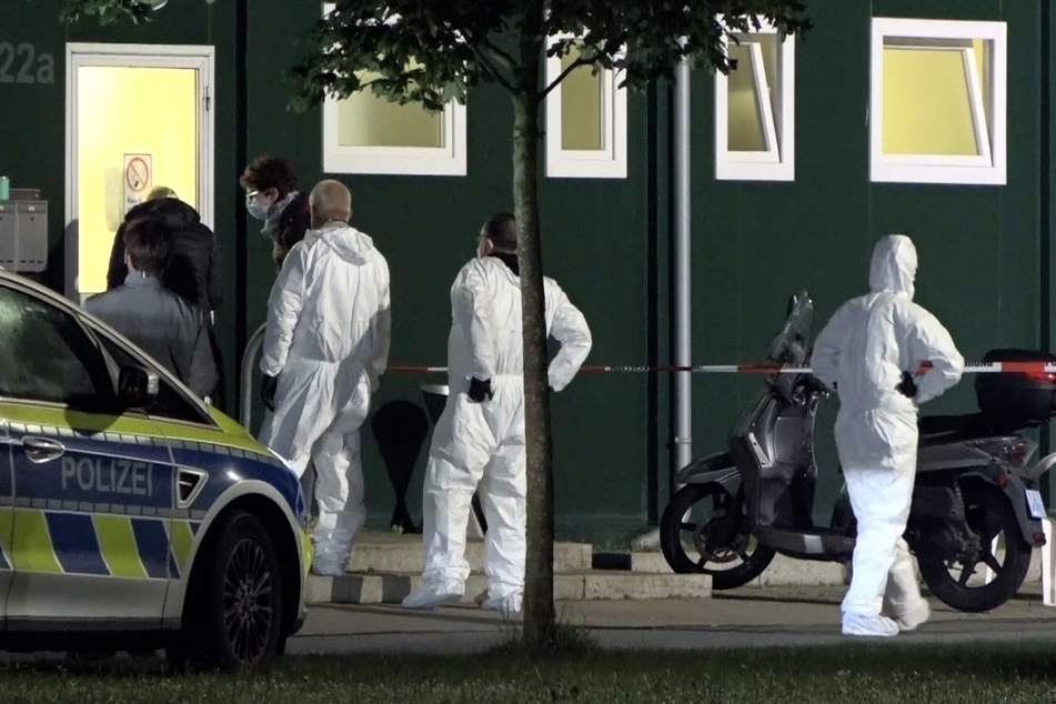 Spurensicherer stehen vor der Asyl-Unterkunft im Münsterland, in dem ein 25-Jähriger einen 35-Jährigen getötet und einen weiteren Mann schwer verletzt hat.