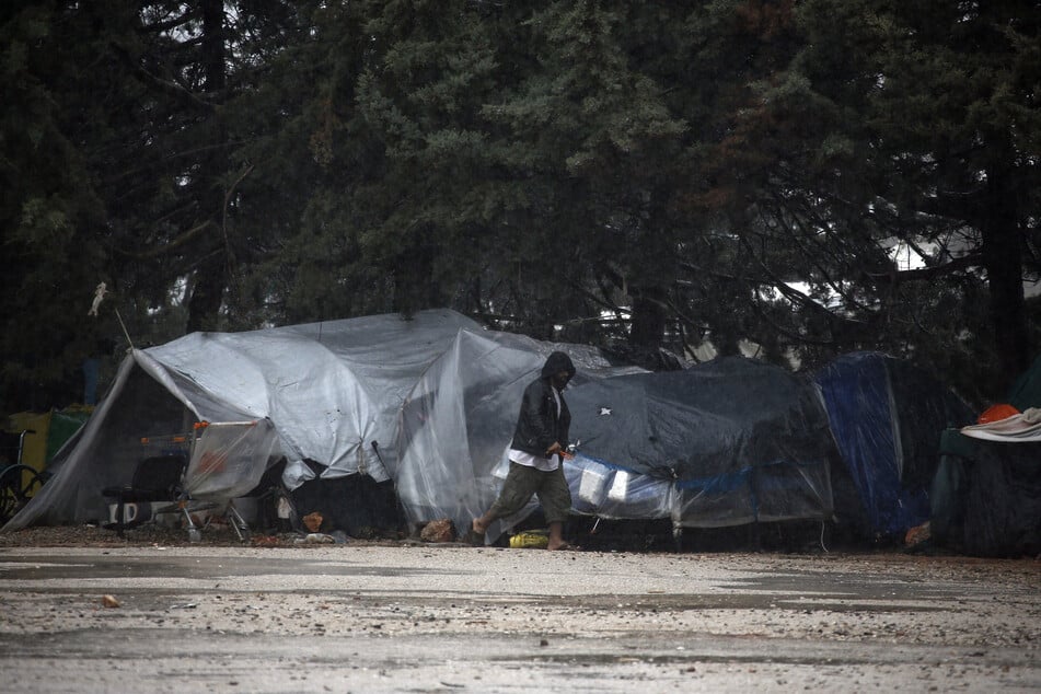 Ein Migrant geht auf dem Gelände des Flüchtlingslagers in Malakasa, rund 45 Kilometer nördlich von Athen, durch den Regen.