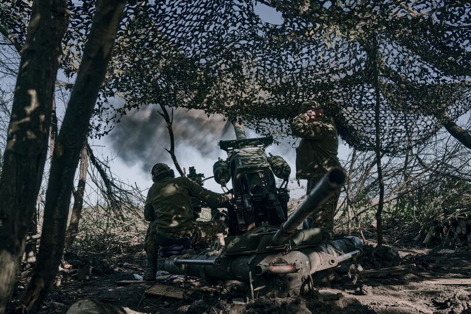 Ukrainische Soldaten feuern eine Kanone auf russische Stellungen an der Frontlinie in der Nähe von Bachmut, Region Donezk.