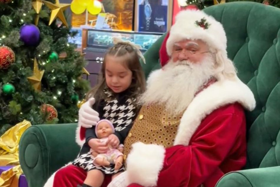 Nachdem die kleine Aurora ihren Wunsch ausformuliert hat, lächelt der Weihnachtsmann verschmitzt in die Kamera von Mama Silvia Solorio.