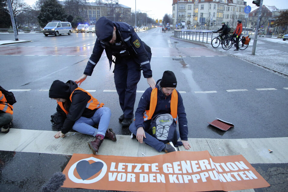 Erst wenn die Polizei vor Ort angekommen ist, beginnen die Unterstützer der "Letzten Generation", ihre Hände an die Straße zu kleben.